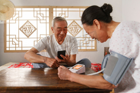 线上医疗摄影照片_老年夫妇在家量血压