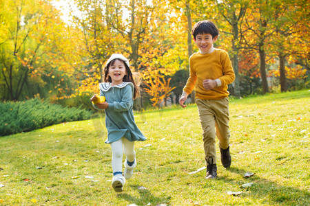 8落叶摄影照片_欢乐的男孩和女孩在公园里奔跑玩耍