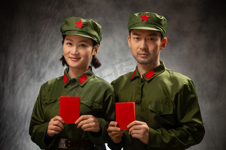 红色复古背景摄影照片_青年夫妇的军装照