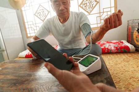 医疗科技女人摄影照片_老年夫妇在家量血压