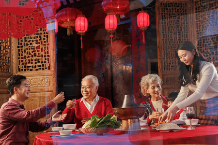 吃火锅的女人摄影照片_幸福的东方家庭过年吃团圆饭