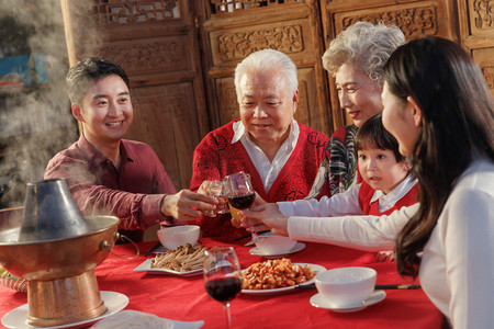 举杯红酒摄影照片_幸福的东方家庭过年举杯庆祝