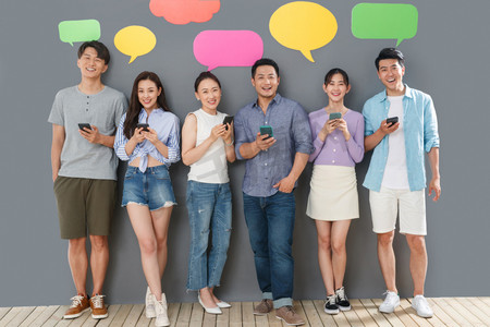 中国框摄影照片_快乐的青年人用手机聊天软件沟通