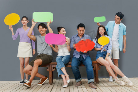 商务对话框png摄影照片_拿着彩色对话框的快乐中青年人