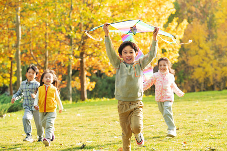 草地里的人摄影照片_快乐的小朋友在公园里放风筝