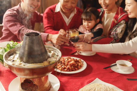 新年签喜庆海报摄影照片_幸福的东方家庭过年举杯庆祝