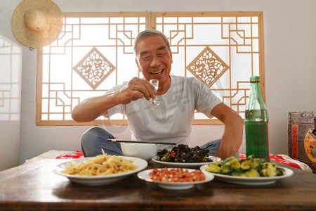 彩色字图摄影照片_老年人坐在家里吃饭喝酒