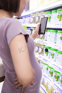 超市里购物的孕妇看手机