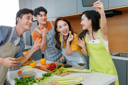 家庭做饭摄影照片_快乐的年轻人在厨房做饭