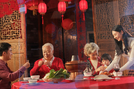 喜庆节日红色元旦摄影照片_幸福的东方家庭过年吃团圆饭