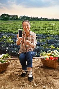 坐在田头的农民拿着手机