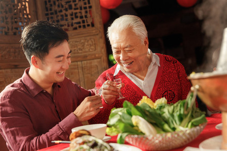 火锅摄影照片_幸福父子吃年夜饭喝酒