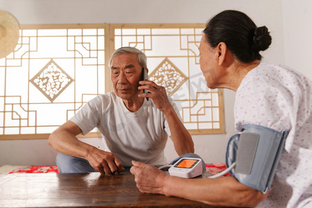科技测量摄影照片_老年夫妇在家量血压