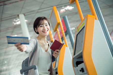 商务女士在机场使用自动售票机