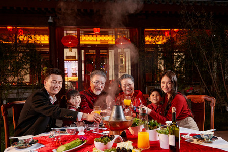 东方家庭在中式庭院内干杯庆祝新年