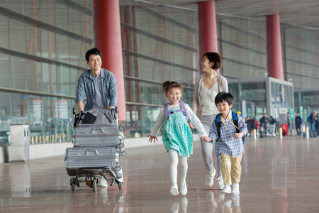 内推活动摄影照片_欢乐家庭在机场推着行李