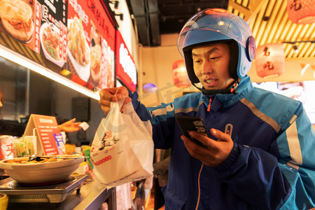 餐厅工作人员摄影照片_外卖员在餐厅取餐