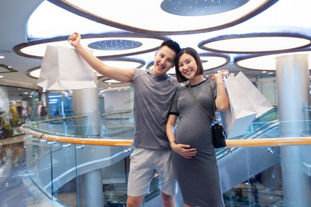 商场购物人物摄影照片_丈夫陪着怀孕的妻子在商场购物