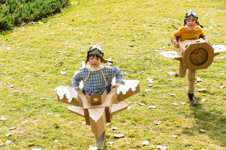 做纸飞机的儿童摄影照片_两个男孩玩开飞机游戏