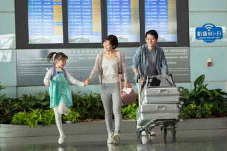内推活动摄影照片_快乐家庭在机场推着行李