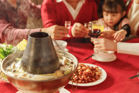火锅饮料摄影照片_幸福的东方家庭过年举杯庆祝