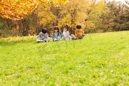 可爱的小朋友们坐在草地上写字
