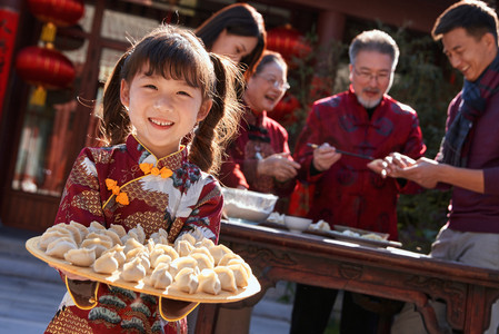 除夕团圆饭图摄影照片_幸福的家庭过年包饺子