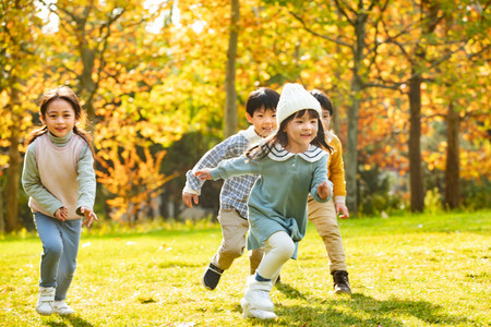4个人摄影照片_快乐儿童在草地上奔跑
