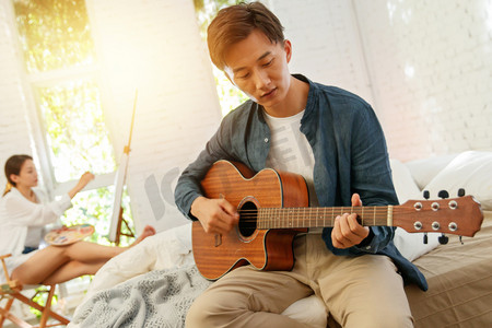 青年男人在家弹吉他