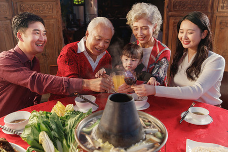 举杯红酒摄影照片_幸福的东方家庭过年举杯庆祝
