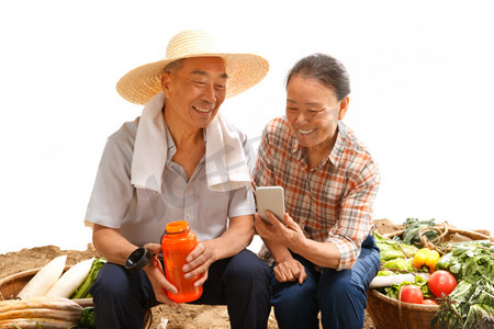 直播聊天摄影照片_农民夫妇坐在田头看手机