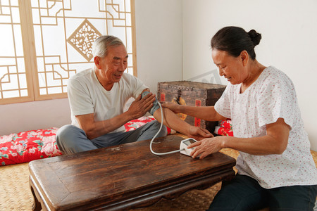 科技新生活摄影照片_老年夫妇在家量血压
