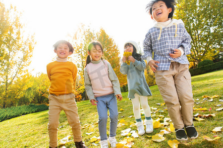 8落叶摄影照片_快乐的小朋友们在公园里玩树叶