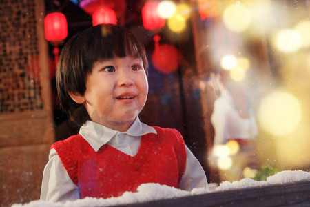 雪摄影照片_可爱的小男孩看向窗外