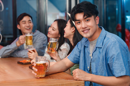 喝酒聚会摄影照片_青年男士和朋友在酒吧喝酒