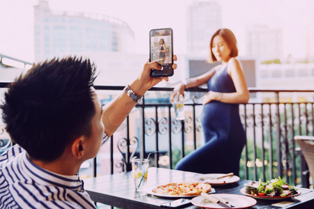 青年夫妇在餐厅用手机照相