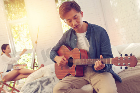 青年男人在家弹吉他
