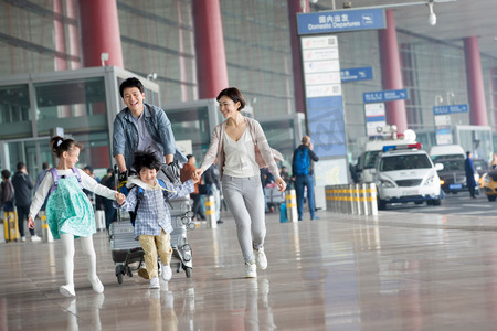 内推活动摄影照片_欢乐家庭在机场推着行李