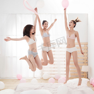 夏天摄影照片_闺蜜在卧室拿着气球玩耍跳跃