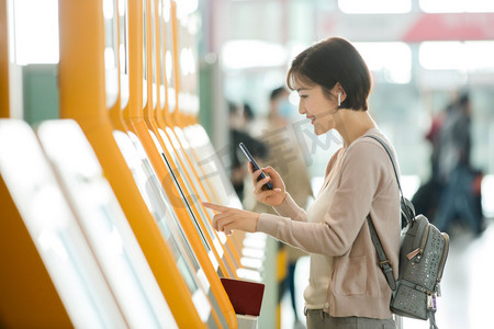 商务女青年出差摄影照片_商务女士在机场使用自动售票机