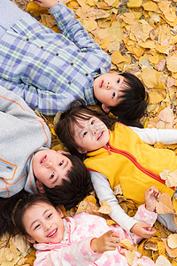 可爱的小朋友们躺在落叶上玩耍