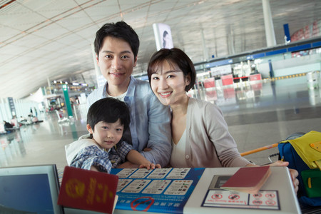 亚洲男孩摄影照片_一家三口在机场出示护照
