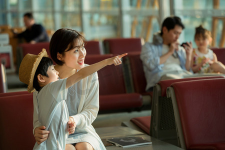 座位图片摄影照片_年轻妈妈和儿子坐在机场候机厅