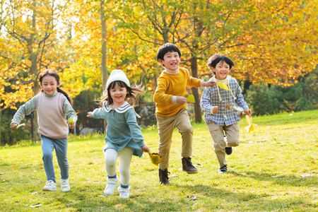 草地落叶摄影照片_小朋友们在公园里快乐奔跑