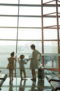 母亲孩子背影摄影照片_年轻妈妈和孩子在机场候机厅往外看