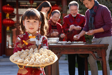 除夕团圆饭图摄影照片_幸福的家庭过年包饺子