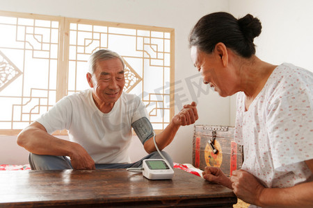 医疗科技女人摄影照片_老年夫妇在家量血压