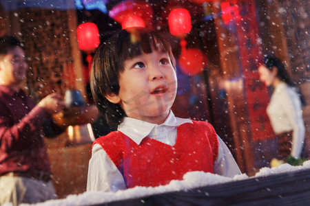 雪摄影照片_可爱的小男孩看向窗外