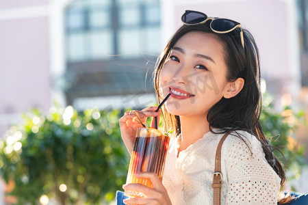 快乐的青年女人品尝夏日饮品