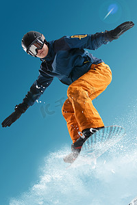 张开手臂的人摄影照片_滑雪的青年男人